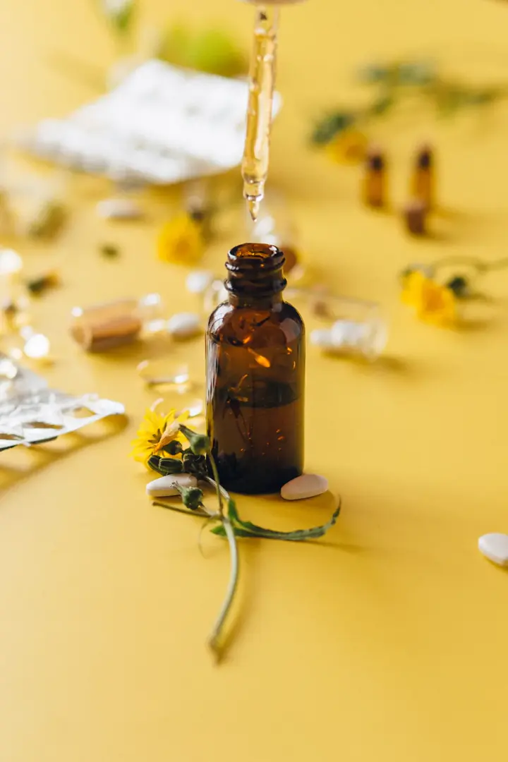 Extrato floral sendo colocado em um frasco âmbar com conta-gotas