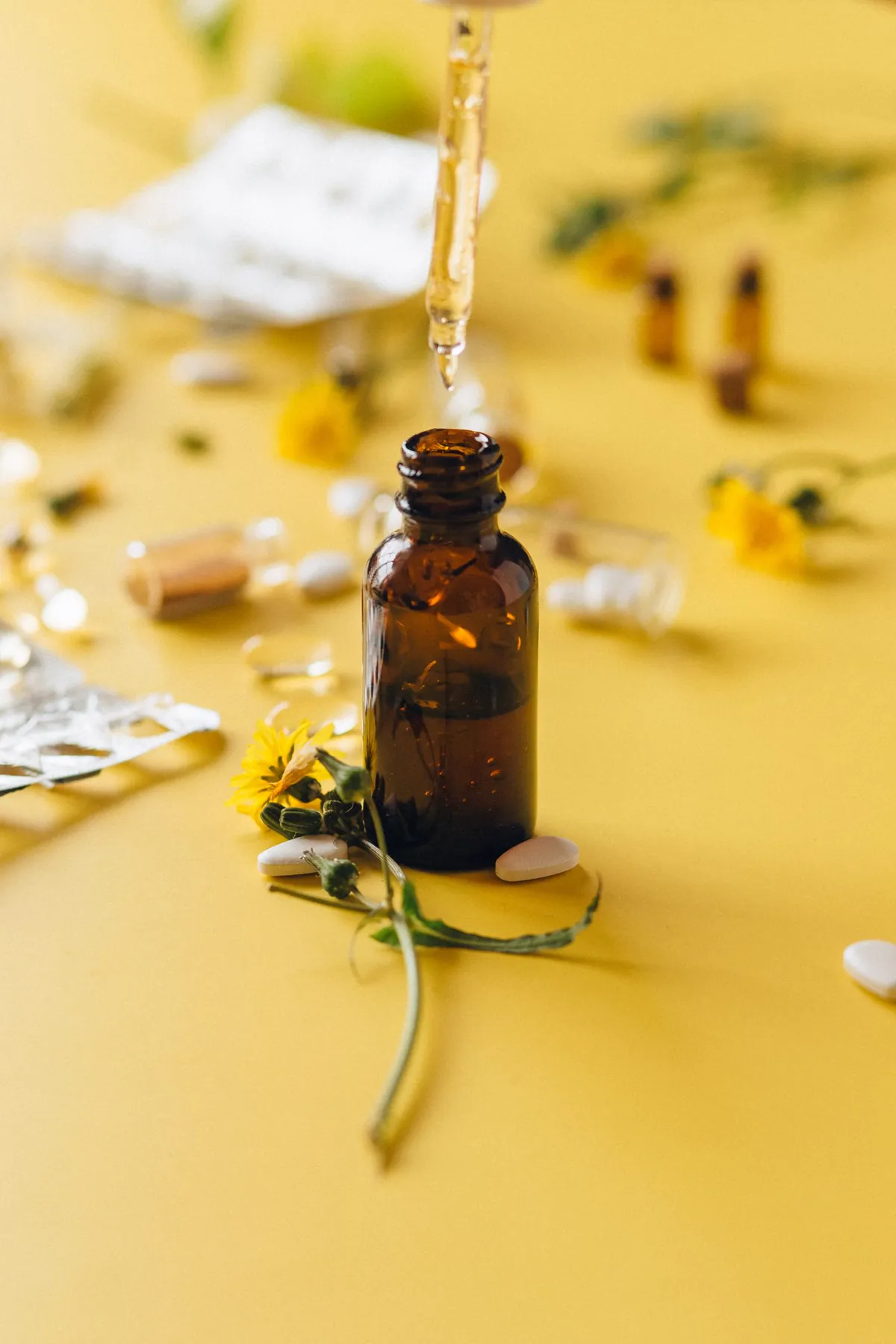 Extrato floral sendo colocado em um frasco âmbar com conta-gotas