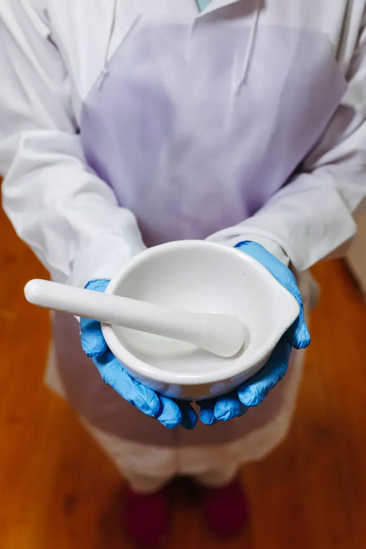Farmacêutica segurando almofariz e pistilo para o preparo de uma fórmula